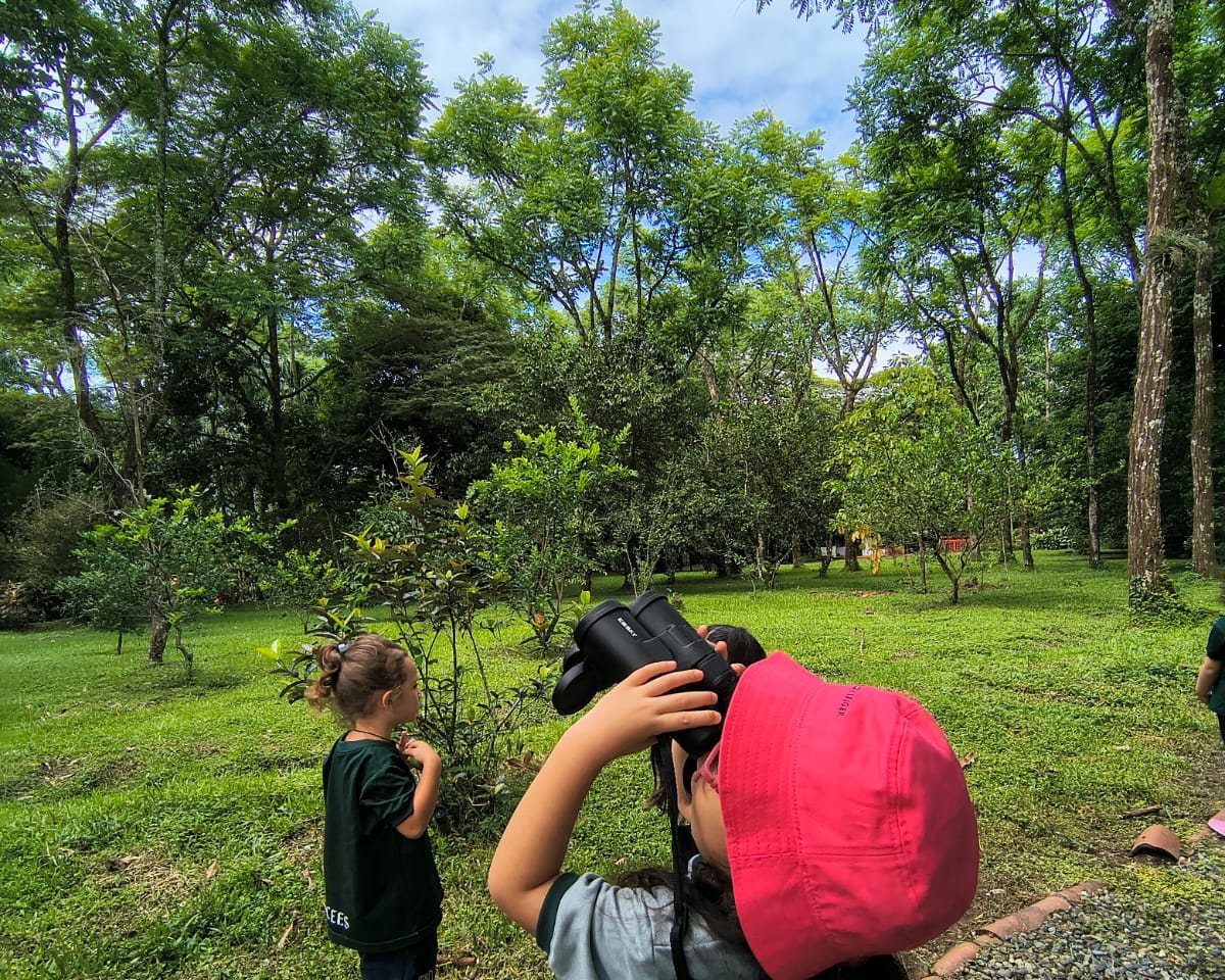 Niñas observando la naturaleza con binoculares en una experiencia de educación ambiental